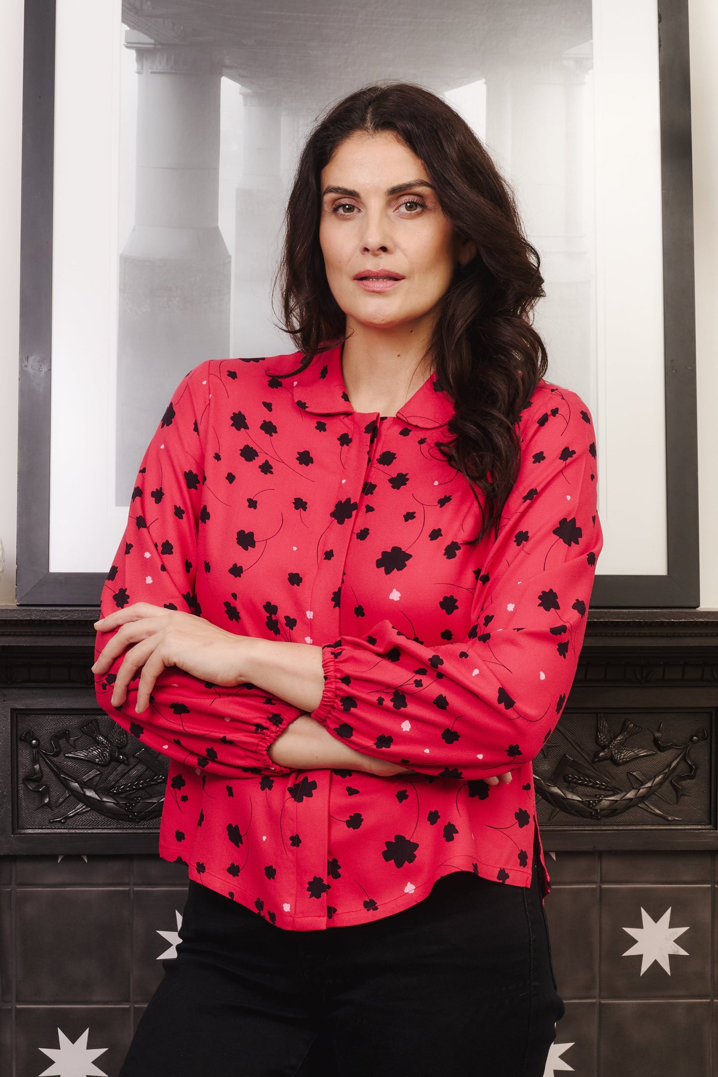 Model with fuller bust wears vibrant crimson coloured blouse, with hidden button, rounded collar and elasticated cuffs. Fabric is 100% LENZING™ ECOVERO™ Viscose - which has a lightly crisp touch with a soft fluid drape. Its fully opaque and has a soft semi-matte sheen.