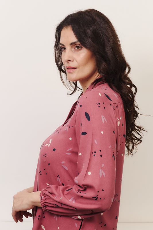 Model with fuller bust wears rose coloured blouse, with hidden button, rounded collar and elasticated cuffs. Fabric is 100% LENZING™ ECOVERO™ Viscose - which has a lightly crisp touch with a soft fluid drape. Its fully opaque and has a soft semi-matte sheen.