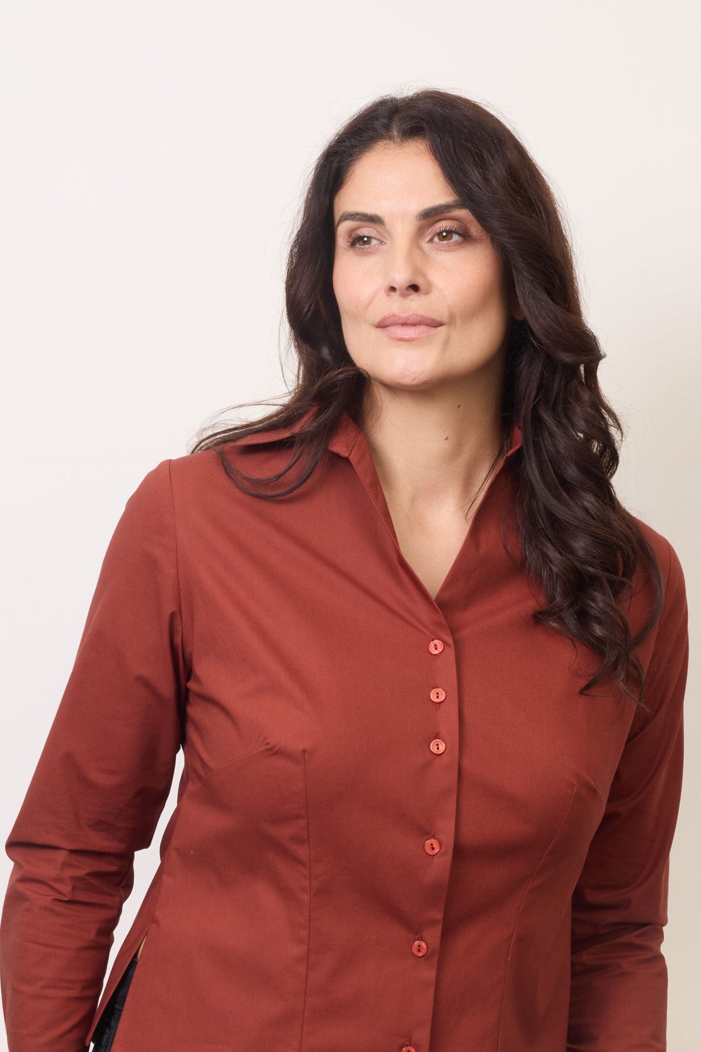 Front view fuller bust model wearing the Cinnamon Nova shirt, designed to flatter curvy figures, a smooth fit without any button gaps, tugging, or constriction around the bust. Tailored with darts to fit your bust, flattering open collar and regular cuff with a single button. 