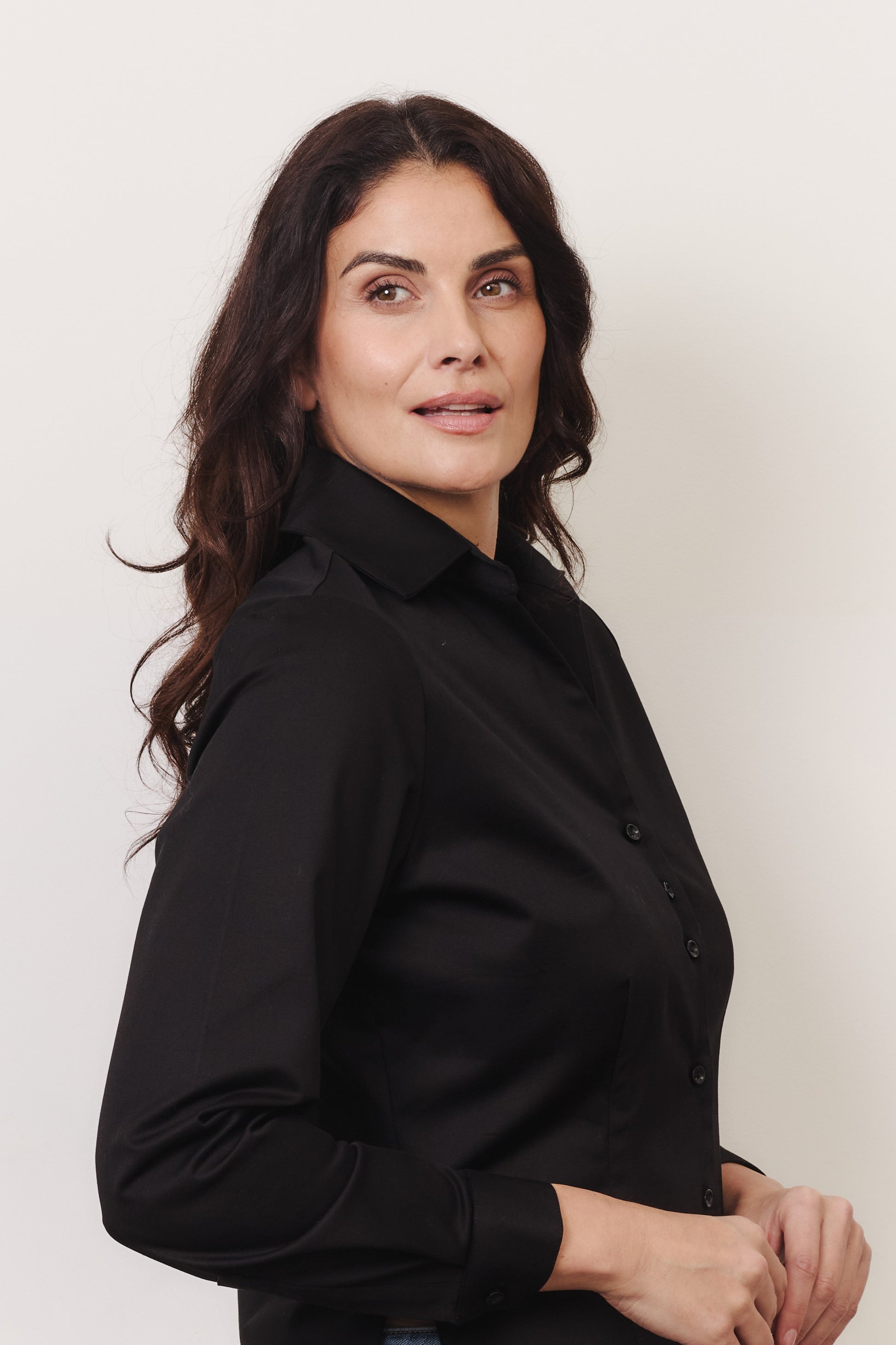 Fuller bust model wearing black organic cotton shirt. Made by Kin+Star.