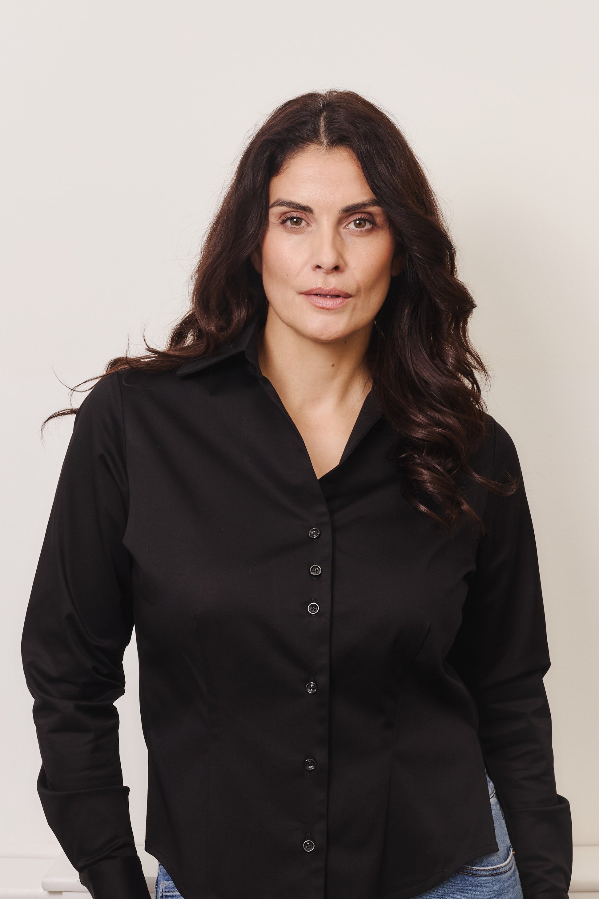 Fuller bust model wearing black organic cotton shirt. By Kin+Star.