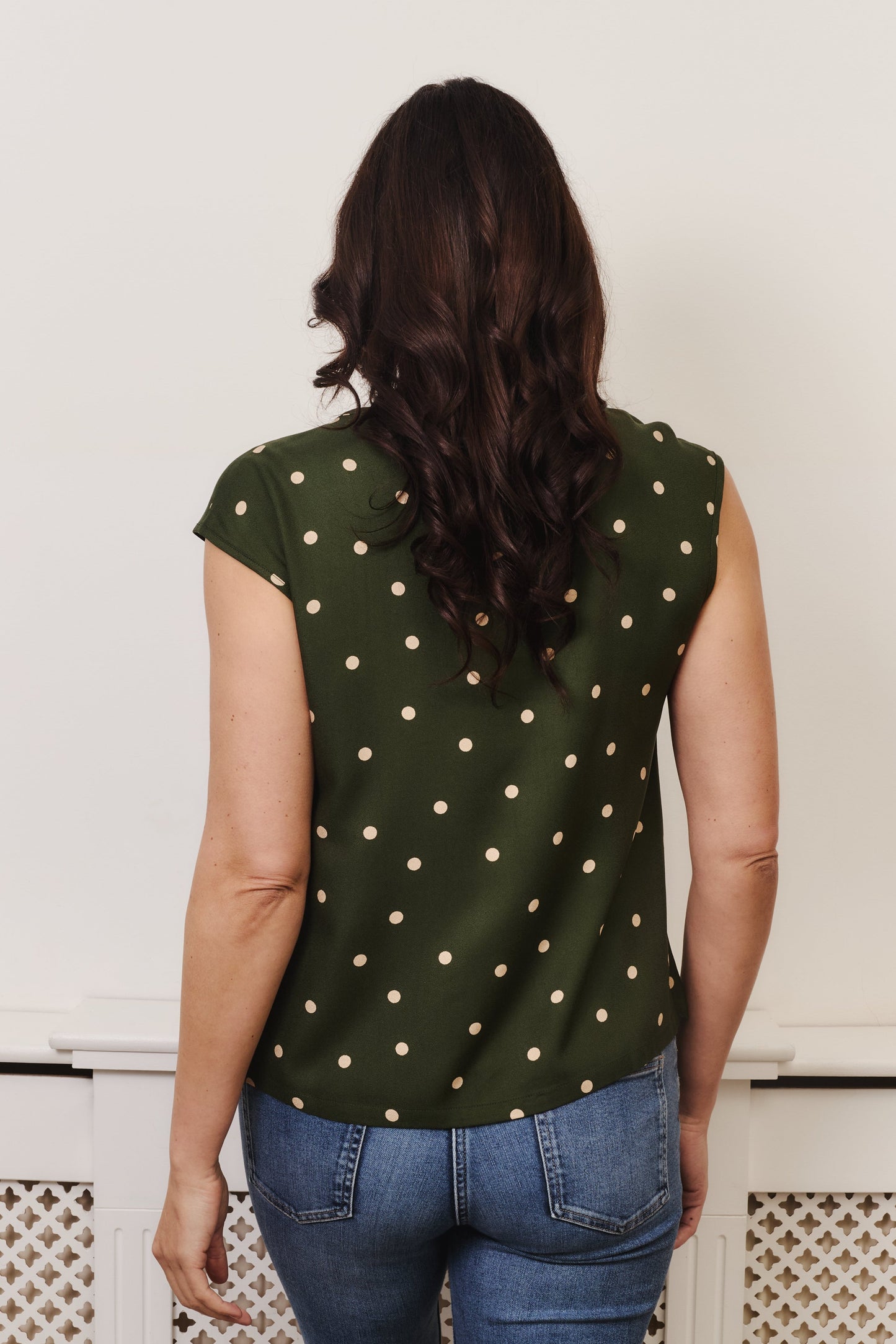 Fuller bust Woman wearing v neck, cap sleeve top, gentle loose fitting in style. Fabric is 100% LENZING™ ECOVERO™ Viscose. The
ECOVERO™ Viscose crepe is a classic crepe with a lightly crisp touch and a soft fluid drape.